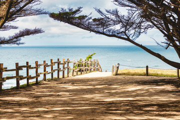 Rustic wooden fence along coastal trail overlooking the ocean. Bright and peaceful seaside scene...