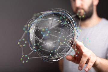 Stock photo of a man interacting with a futuristic holographic globe, representing global network...