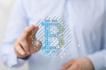 Close-up of a hand interacting with a digital Bitcoin symbol. Cryptocurrency, finance, technology.