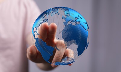 Hand interacting with a digital 3D globe, showcasing global connectivity and technology.