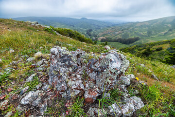 Winding trail through the lush, green hills of Marin Headlands near Rodeo Beach, overlooking the...