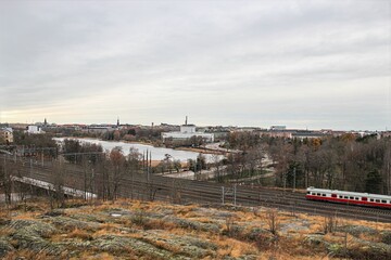 Train on railway tracks with city view of Helsinki on overcast autumn day