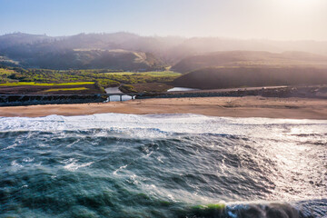 Aerial view of Scott Creek Beach along California scenic Highway 1. Rugged cliffs, gentle waves,...