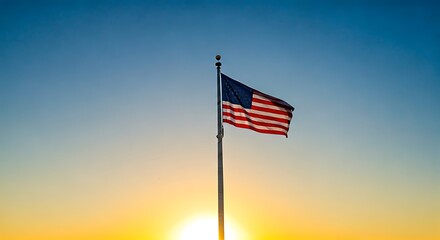 American flag proudly waves against a vibrant sunset sky, creating a patriotic and serene moment.