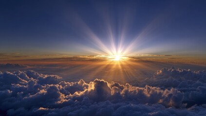 Sunrise breaking through clouds.  Vast cloudscape below a brilliant sunrise, sun rays radiating outward