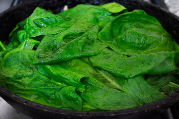 Close up of green spinach leaves being cooked