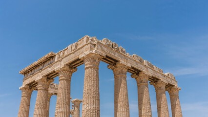 Fototapeta premium Majestic columns from a bygone era's temple showcased against a pristine blue sky