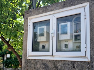 Outdoor Electric Meter Box with White Framed Glass on Concrete Wall