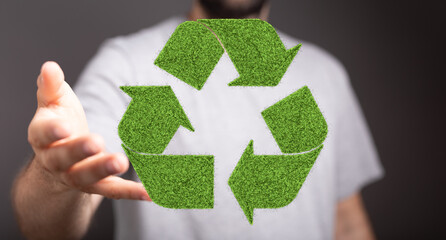Man presenting a green recycle symbol. Eco-friendly, sustainability concept.