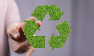 Eco-friendly recycling concept. Hand interacting with a grass recycle symbol. Sustainable living.