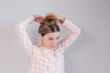 Young woman styling her hair in front of a mirror