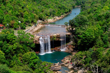 Aerial view of Krang Suri Waterfall, Meghalaya, amidst lush green forest.
