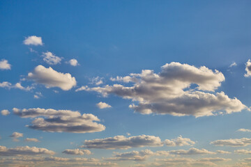 High layers of Cumulonimbus clouds against a bright blue sky herald upcoming weather changes,...