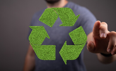 Man interacts with a green recycling symbol. Eco-friendly concept. Sustainable future.