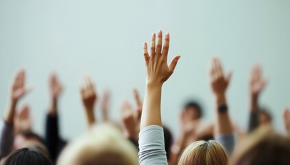 Hands Raised in Participation during Workshop or Conference with Engaged Audience in Background