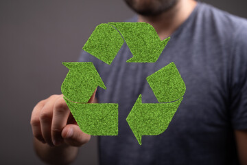 Man interacts with a green recycle symbol. Eco-friendly concept. Sustainability.