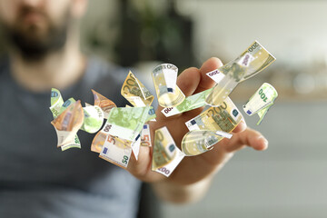 Image of a man's hand catching falling euro banknotes.  Perfect for finance, wealth, or success...