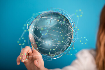 Stock photo of a woman interacting with a holographic globe, representing global network,...