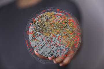Image depicts a person holding a virtual globe showing interconnected data points, representing...