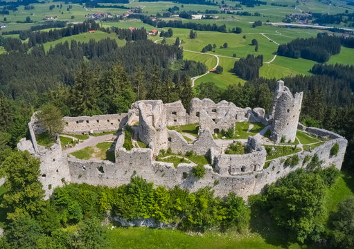 Aerial view of the majestic ruins of Eisenberg Castle stand proudly amidst lush green hills and dense forests, a stark contrast of stone against nature's vibrant hues, Eisenberg, Bavaria, Germany.