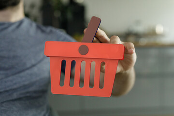 Image of a man holding a digital shopping basket icon. Perfect for e-commerce, online shopping, and...