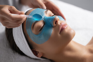 woman applying blue jelly mask