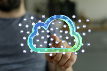 Man interacts with a digital cloud, symbolizing data storage and networking.