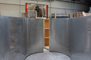 Plaques de t&ocirc;le pli&eacute;e rang&eacute;es &agrave; la verticale dans un atelier de m&eacute;tallurgie.