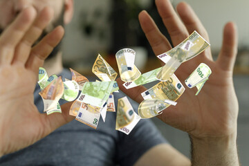Image of a man's hands catching many falling euro banknotes.  Perfect for finance, wealth, or...