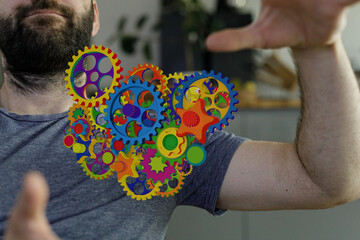 Image of a man with colorful gears superimposed on his shirt. Concept of creativity and innovation.