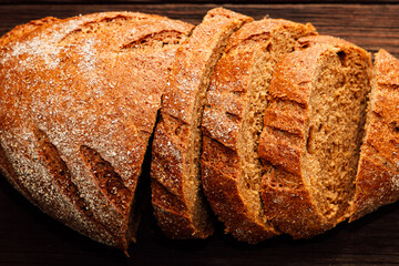 Warm bread loaf sliced and ready for serving on wooden surface at breakfast time