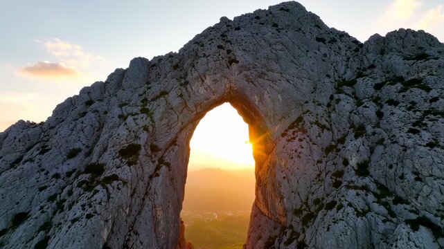 Majestic Mountain Archway at Sunset: Golden Hour Landscape Drone Shot