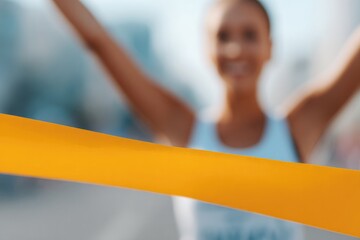 portrait of person crossing finish line ribbon at local marathon arms raised in confident victory
