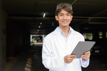 Young scientist student researcher wearing lab coat using tablet computer