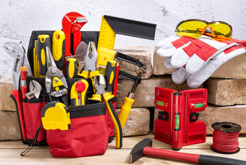 Tool belt with tools next to old bricks