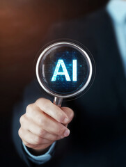 Business man hold a magnifying glass up to a AI artificial intelligence hologram.