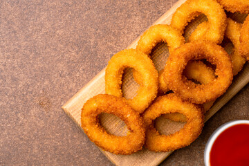 Fried onion rings on vintage brown  background