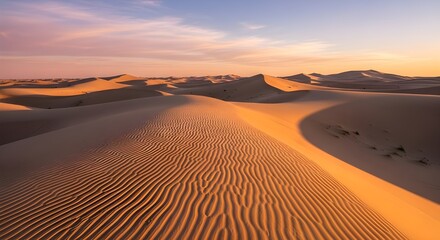 Scenic desert landscape at golden hour featuring soft sand dunes, ripples, long shadows, sparse vegetation, and a colorful gradient sky during sunrise or sunset