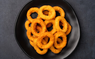 Fried onion rings on black background