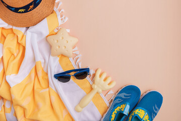 Children's beach essentials including  shoes, sunglasses, towel, and starfish.
