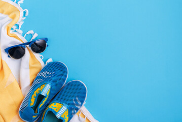 Children's beach essentials including  sunglasses, water shoes  and towel.