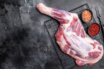 Fresh raw lamb shoulder, leg perfect for slow cooking or roasting to create a tender, flavorful meal. black background. top view