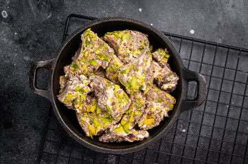 Oriental Halva with pistachio in a skillet. Natural vegan sweets. black background. top view.