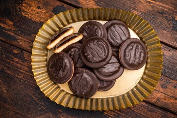 Steel plate with  Jaffa Cookies covered with chocolate and filled with jam. Wooden background. top view