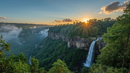 Sunrise over misty cliffs featuring a cascading waterfall surrounded by lush greenery and foggy valleys under a clear sky
