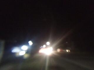 Defocused abstract background, vehicle lights at night.