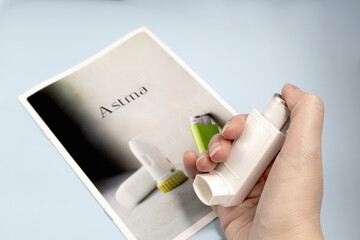 Female hand holding asthma medications inhaler. High quality photo