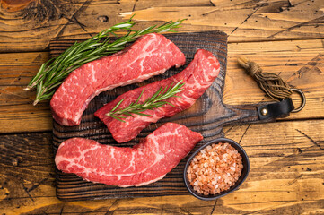 Raw marbled beef Steak, beef meat on wooden board with herbs. wooden background. top view