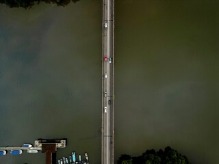 Morning traffic on bridge with river and mangrove area.