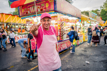 Portrait of a charismatic vendor selling his wares at a local fair in Latin America. The man is...